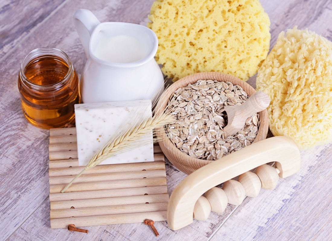 prikaz ovsenih pahuljica, masažera za noge, mleka, meda, sunđera na beloj pozadini