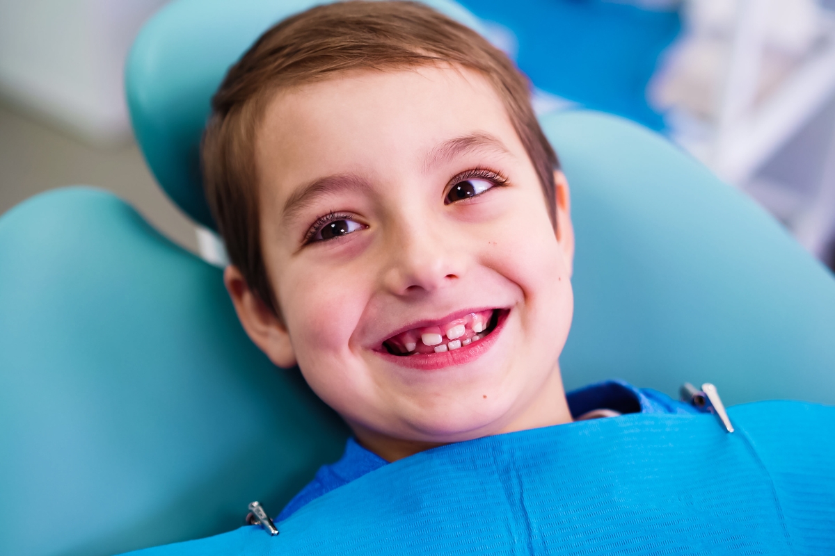 dečak sedi u zubarskoj stolici