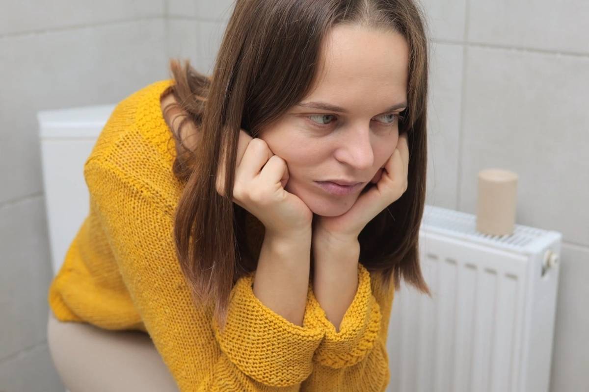 devojka koja pati od hemoroida sedi na wc šolji